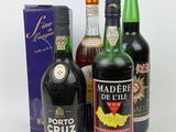 three bottles of wine and a box of liquor on a white surface