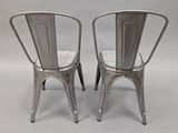 pair of silver metal chairs on a grey background