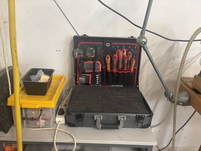 une caisse à outils avec des outils posés sur une table