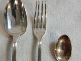 trois cuillères en argent et deux cuillères en argent sur une table