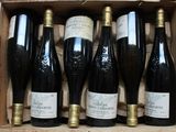 six bottles of wine are in a wooden box on a table