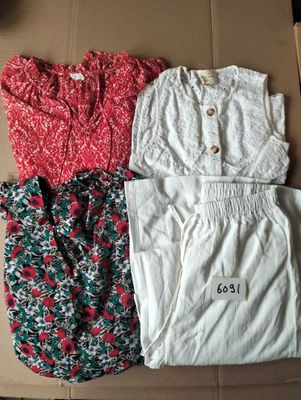 trois vêtements posés sur une boîte en carton