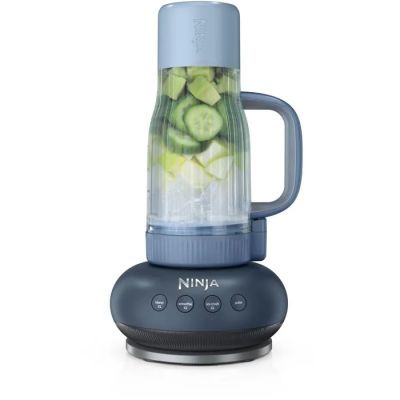 a blue blender with cucumbers in it on a white surface