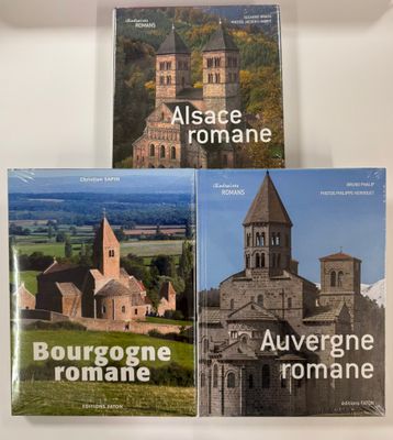 three books on a white table with a picture of a church in the background