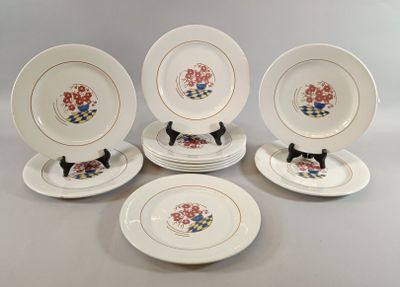 six assiettes blanches ornées de chats noirs et de fleurs, posées sur une table