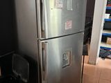 a stainless steel refrigerator and trash can in the kitchen