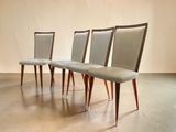 three chairs with upholstered seats sit in a row on a concrete floor