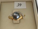 a ring with a pearl and diamonds in a box