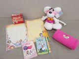 a teddy bear sitting next to a bunch of stationery items