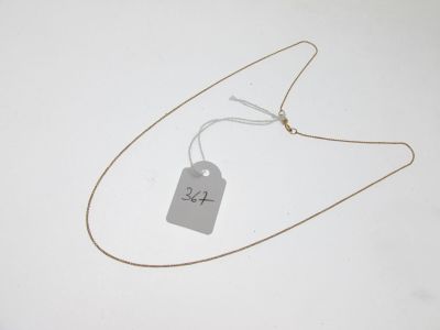 une étiquette fixée à un collier sur un fond blanc