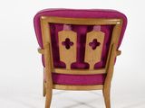 the back of a pink chair with wooden legs and a pink cushion