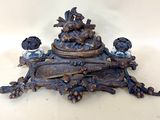 a bronze clock with birds on it on a table