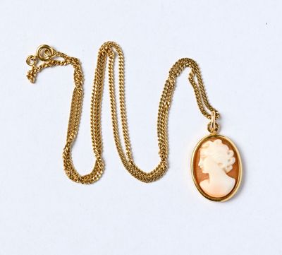 un gros plan d'un collier en or sur lequel figure le portrait d'une femme