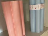 a pink and blue trash can and a blue and white trash can on a shelf