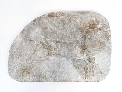 a rock with a horse on it on a white surface