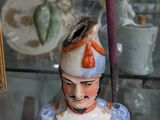 a figurine of a man in a hat on a glass shelf