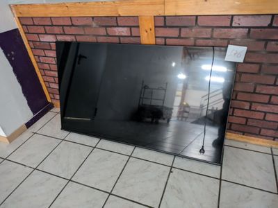 a large mirror sitting on the floor in front of a brick wall