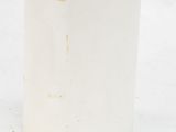 a white vase with a black handle on a snow covered ground