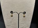 a close up of a pair of earrings on a display stand
