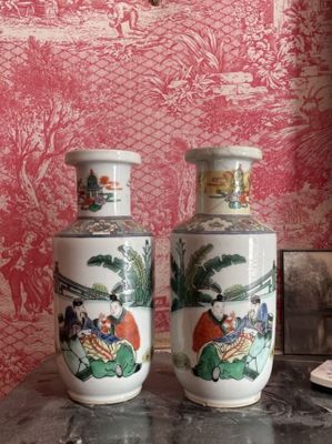 deux vases posés sur une table devant un mur