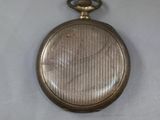 a silver pocket watch on a white surface