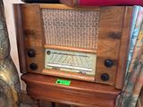 une pile de valises posée sur une table, à côté d'une vieille radio