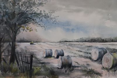 un tableau représentant des bottes de foin dans un champ, près d'un arbre