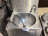 un évier en acier inoxydable placé à côté d'une cuisinière en acier inoxydable
