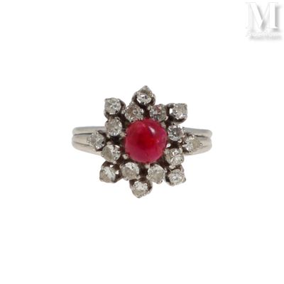 une image d'une bague avec une pierre rouge entourée de diamants blancs