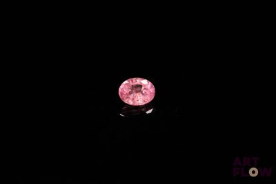 a pink diamond in the dark with a black background