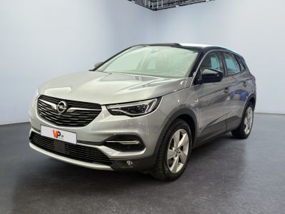 une Opel argentée garée dans une pièce au sol noir