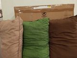 three pillows on a cardboard box in the middle of a room
