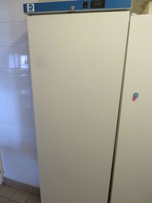 un réfrigérateur blanc avec une porte bleue dans une cuisine