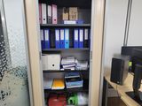 a small open door in a room with a desk and a computer