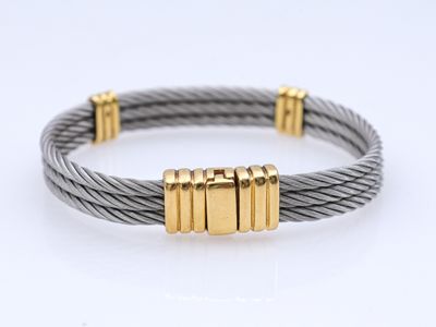 un gros plan d'un bracelet en tresse orné de deux lingots d'or