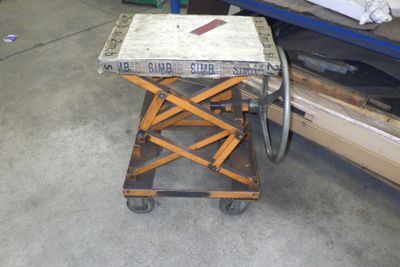 une petite table sur laquelle est posé un couteau, dans un garage
