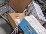 a pile of boxes sitting on the ground next to a shopping cart