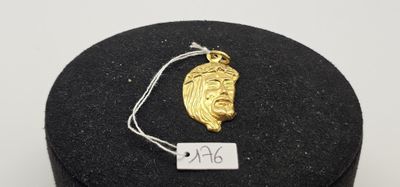 un gros plan sur un collier en or orné d'un visage de Jésus