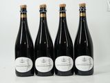quatre bouteilles de vin sont alignées sur une table