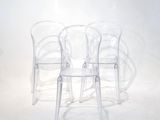 three clear plastic chairs sitting next to each other on a white surface
