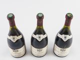 three bottles of wine are lined up on a white surface