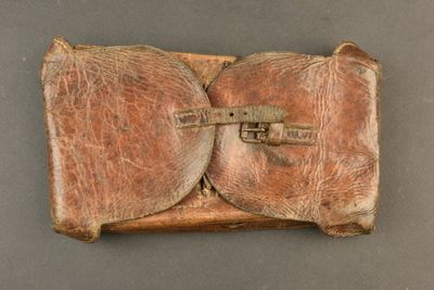 an old brown leather case with a latch on top of it