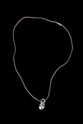 un collier en argent orné d'une boule en argent sur fond noir