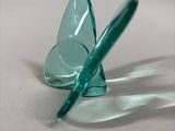 a glass object that looks like a butterfly on a table