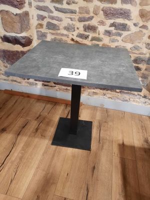une petite table sur laquelle est inscrit un chiffre, devant un mur de pierre