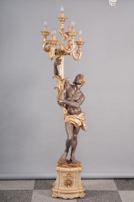 statue d'un homme tenant un lustre, posée sur un socle en marbre