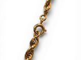a close up of a gold chain with a clasp on a white background