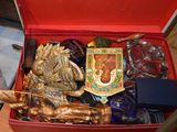 une boîte rouge remplie d'objets divers, posée sur une table