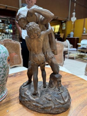 a bronze statue of a man and a woman on a table