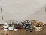 many different types of teapots and cups on the table